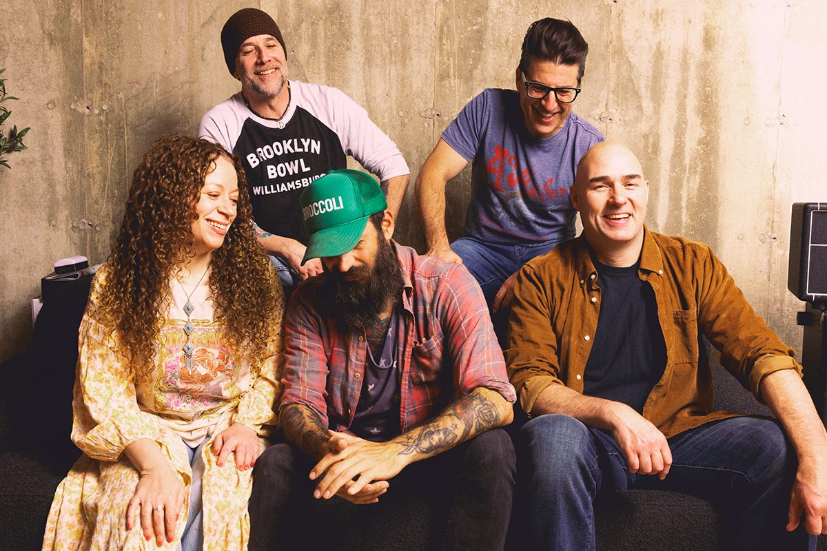 The Moonrise Cartel band members smiling together indoors.